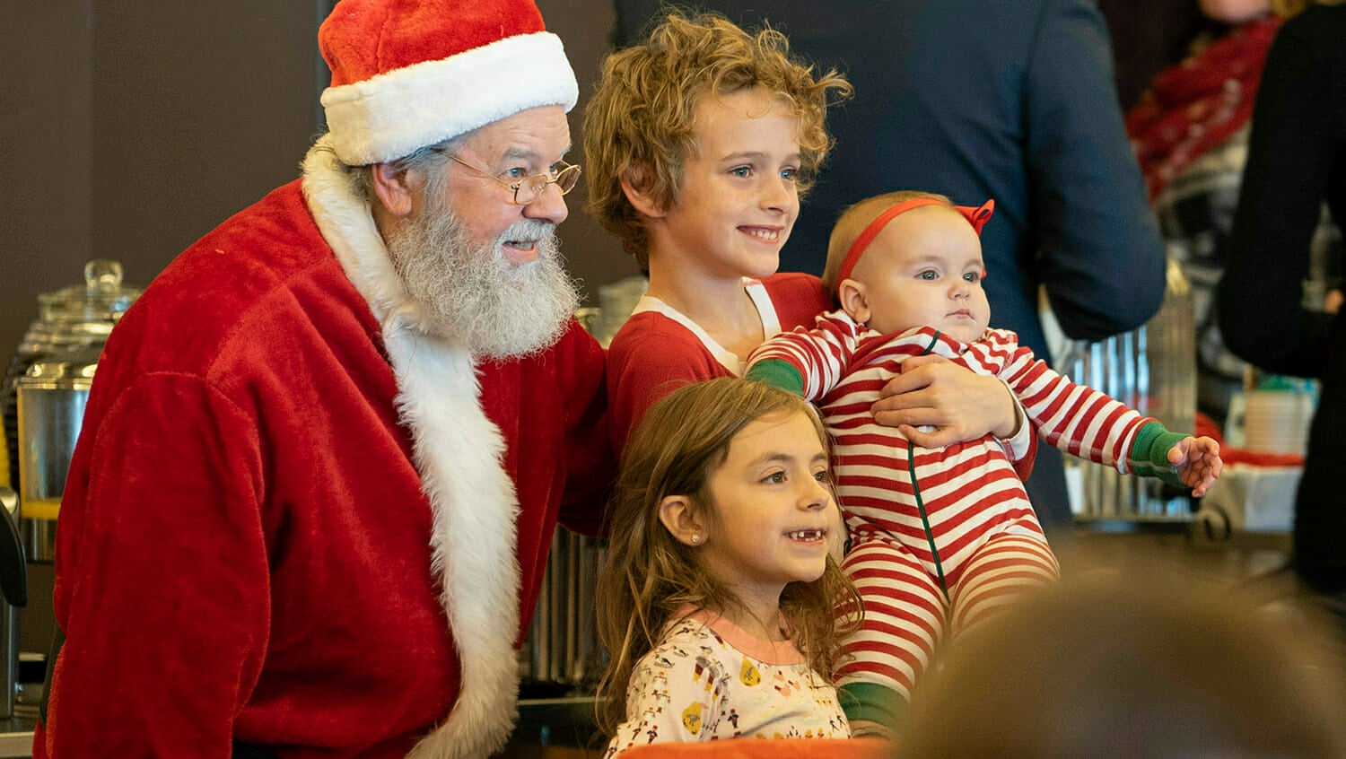 Santa posing for a photo with a group of children